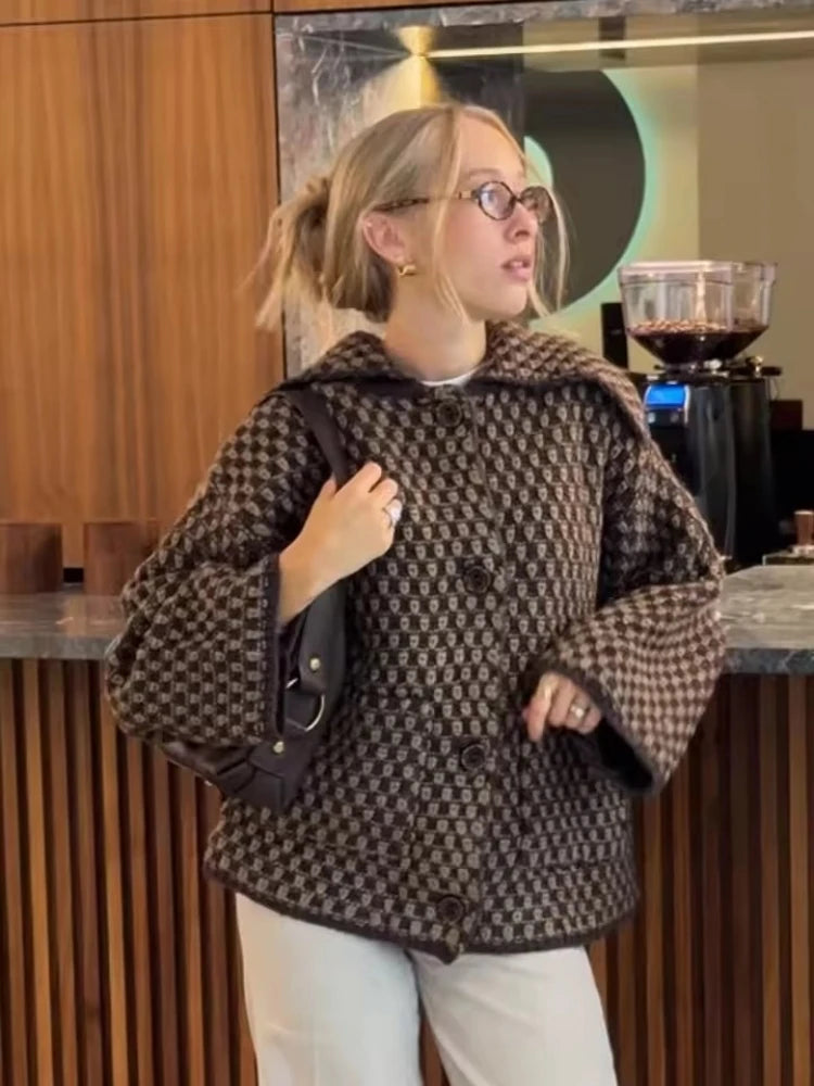 Brown check knit cardigan with wide collar worn with white trousers