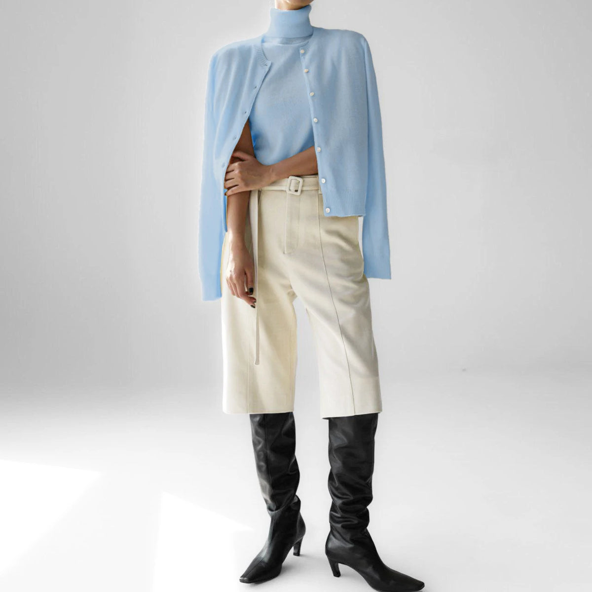 Pale blue knit tank and cardigan set styled with trousers and boots