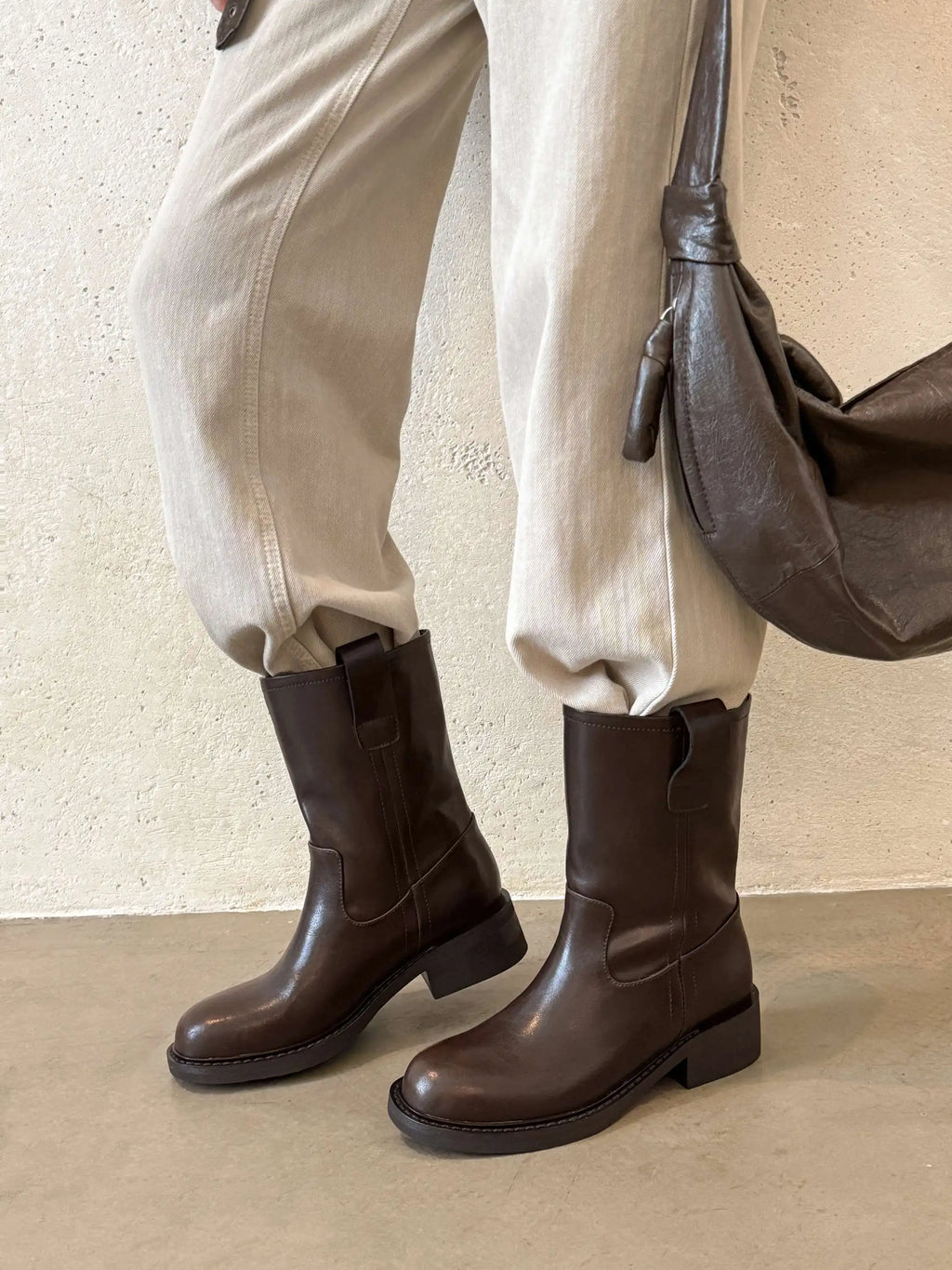 Dark brown leather mid calf western boots worn with light trousers
