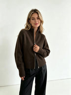 Dark brown zip up cardigan with black trousers, front view