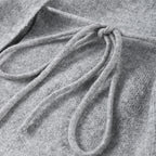 Close-up of the side tie on a grey knit cardigan