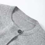 Close-up of the round neckline and single button on a grey cardigan