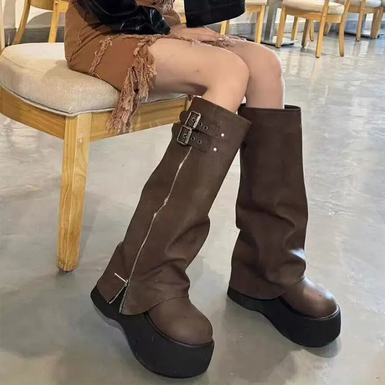 Brown platform boots with side zip and buckle straps, seated view