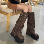 Brown platform boots with side zip and buckle straps, seated view