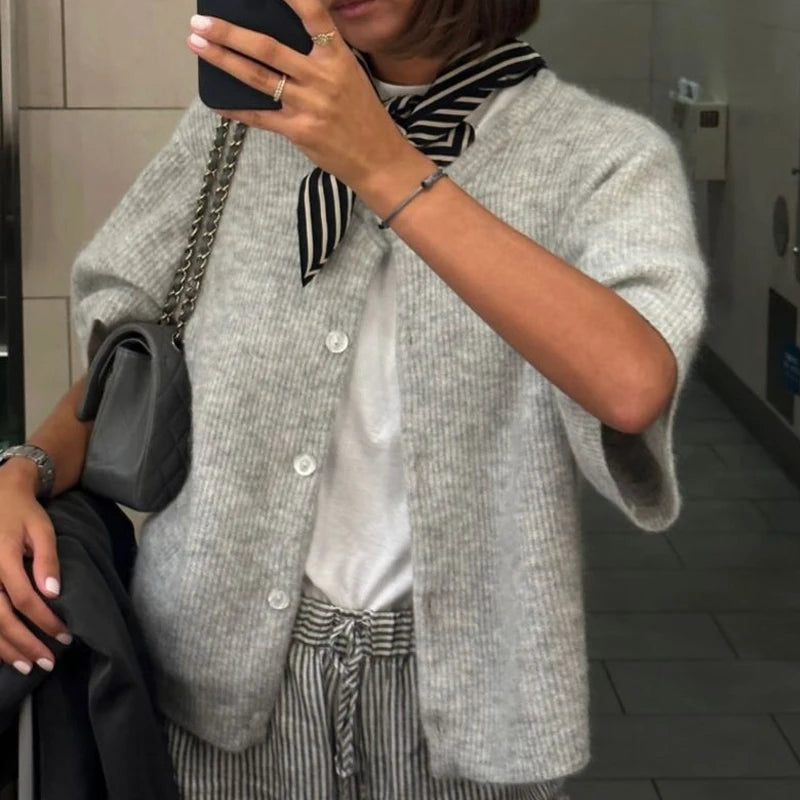 Light grey short sleeve button cardigan worn over a white tee