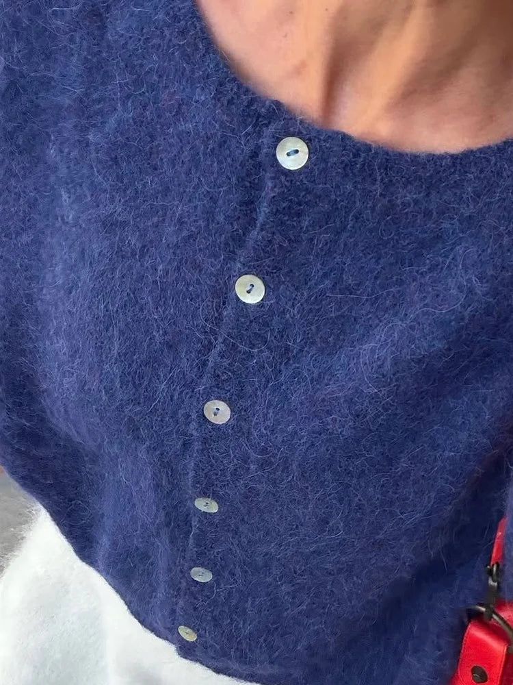 Close-up of the soft fuzzy knit and buttons on a navy cardigan