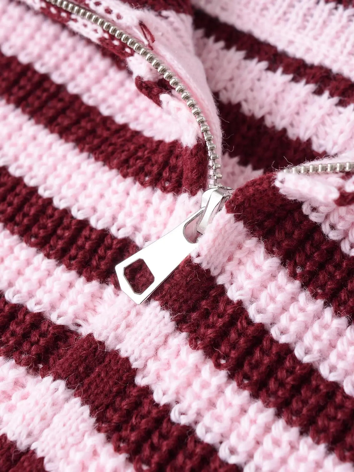 Close-up of the double zip on a striped knit cardigan