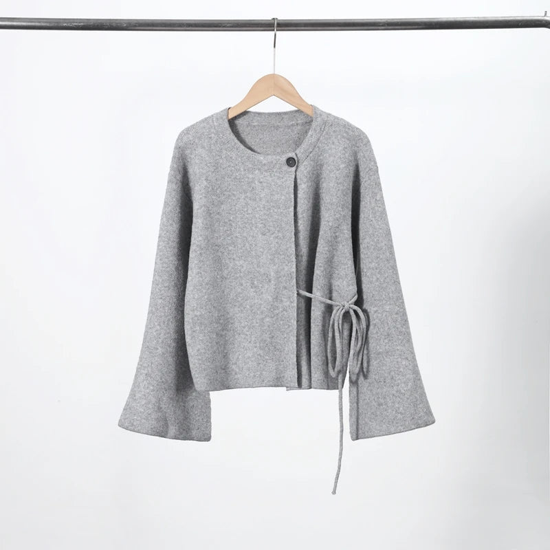 Grey knit cardigan with side tie on a hanger