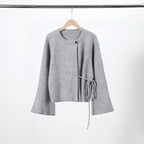 Grey knit cardigan with side tie on a hanger