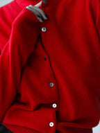Close-up of the buttons on a red knit cardigan