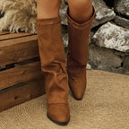 Tan brown faux suede fold over boots with metal buckle detail, worn standing