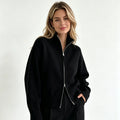 Black zip up cardigan with stand collar and black trousers