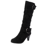Black slouchy heeled boot with ring buckle strap on a white background