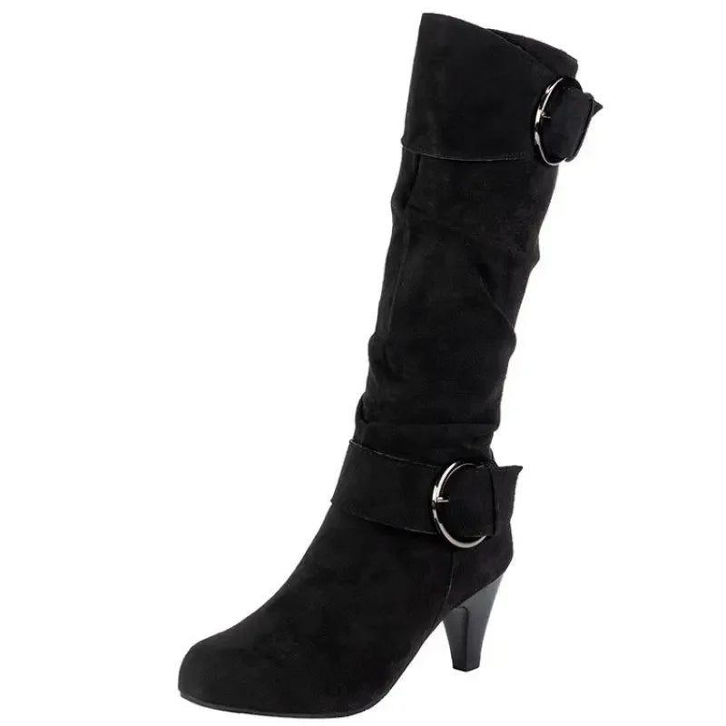 Black slouchy heeled boot with ring buckle strap on a white background