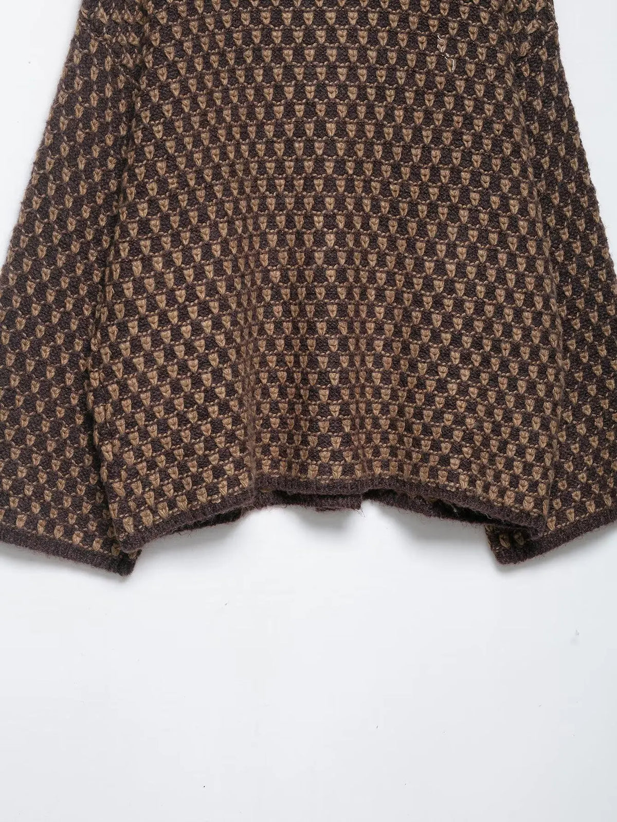 Wide sleeve of a brown and tan check knit cardigan