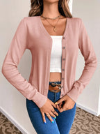 Blush pink V neck button cardigan front view with a white crop top