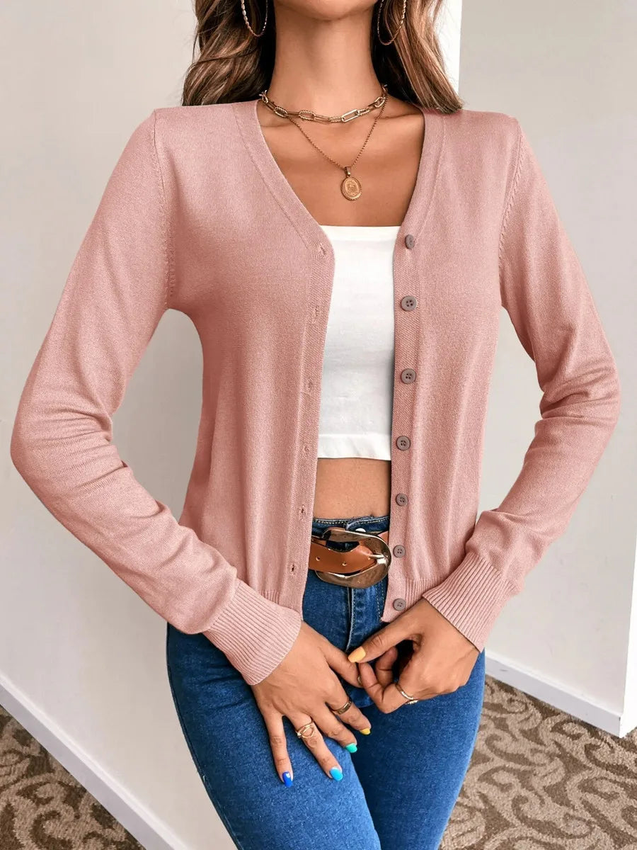 Blush pink V neck button cardigan front view with a white crop top