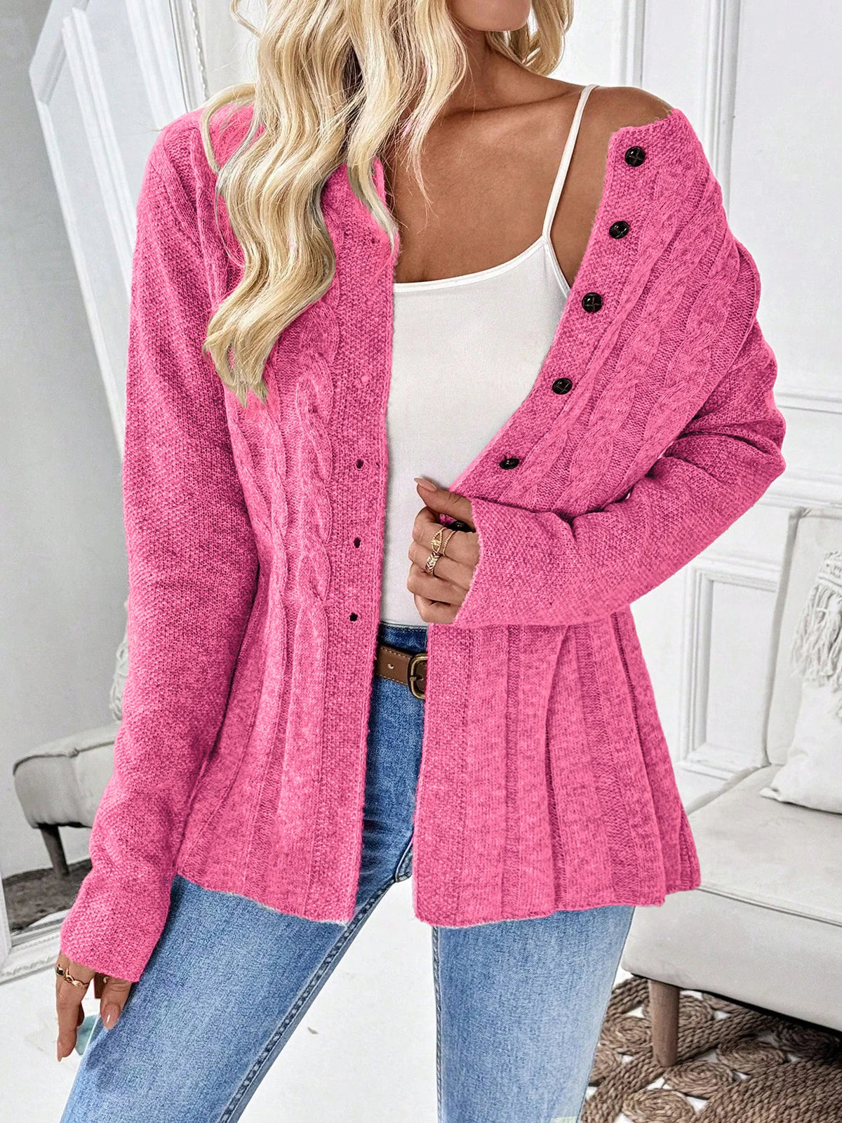 Hot pink cable knit button cardigan worn off the shoulder