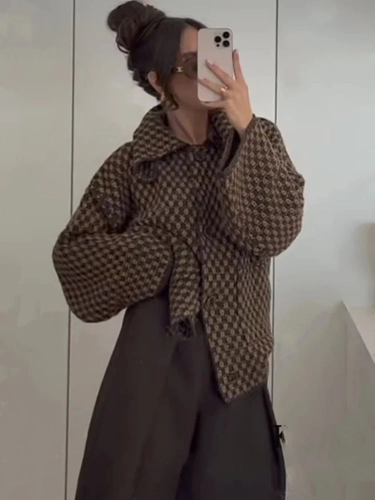 Brown check knit cardigan with a wide collar worn open over a dress