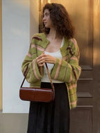 Olive green striped button cardigan worn with a white top and black skirt