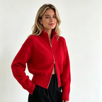 Red zip up cardigan with stand collar and black trousers
