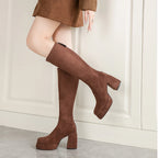 Brown platform knee high boots worn with a brown jacket