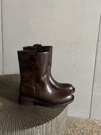 Brown leather mid calf western boots on a stone surface
