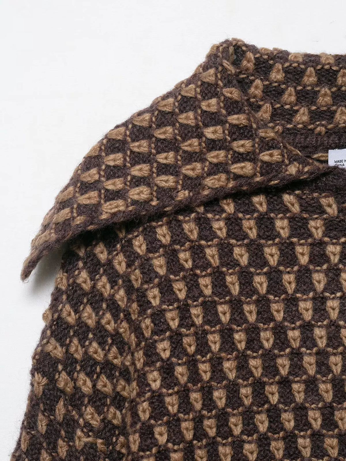 Close-up of the wide collar on a brown and tan check knit cardigan
