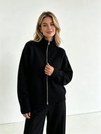 Black zip up cardigan with black trousers, front view