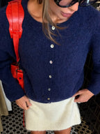 Navy button front cardigan worn with a cream mini skirt
