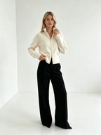 Ivory zip up cardigan with black trousers, standing pose