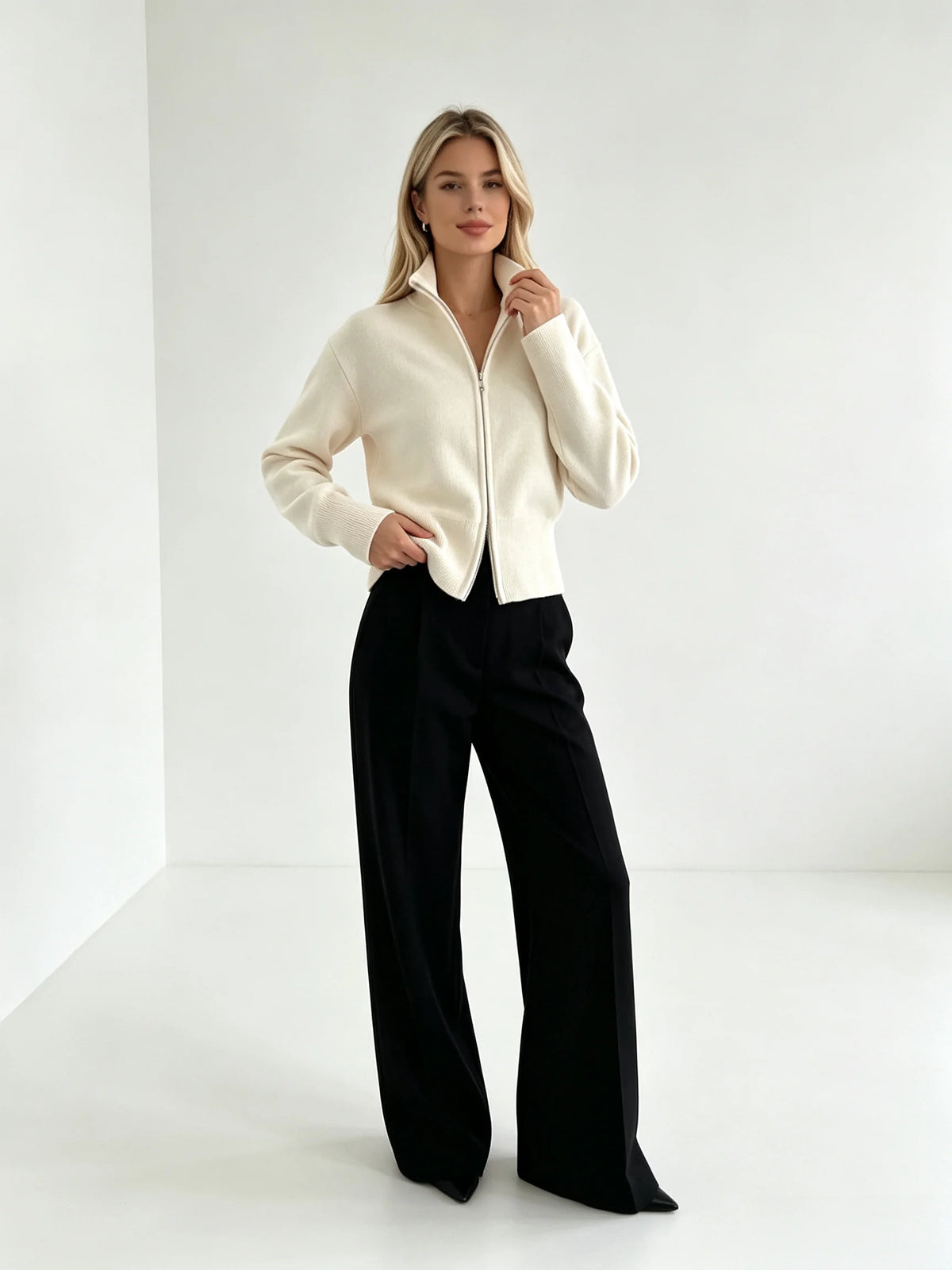 Ivory zip up cardigan with black trousers, standing pose