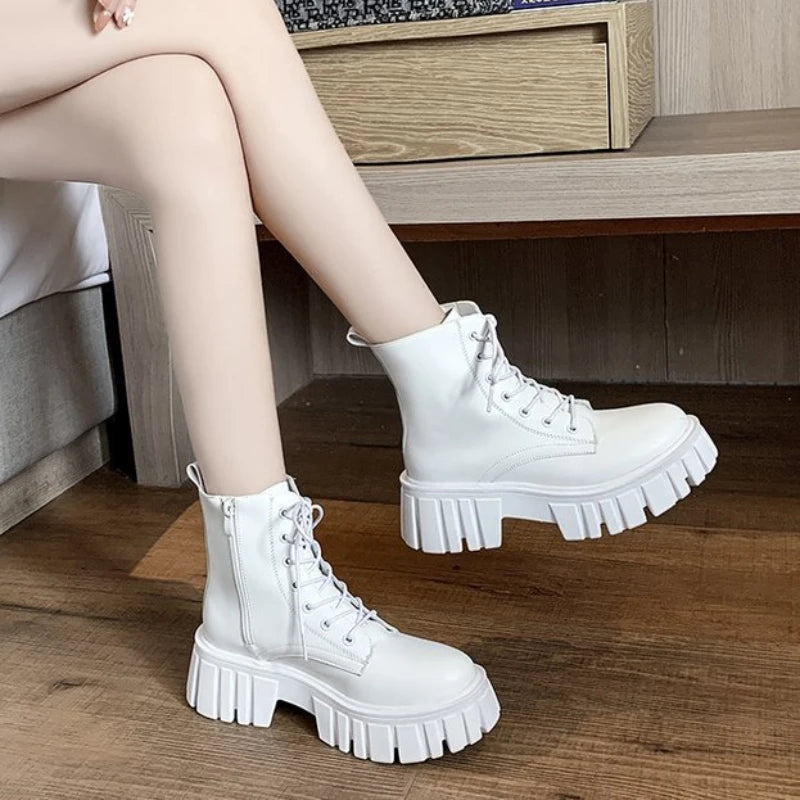 White chunky sole lace-up ankle boot worn with legs crossed