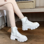 White chunky sole lace-up ankle boot worn with legs crossed