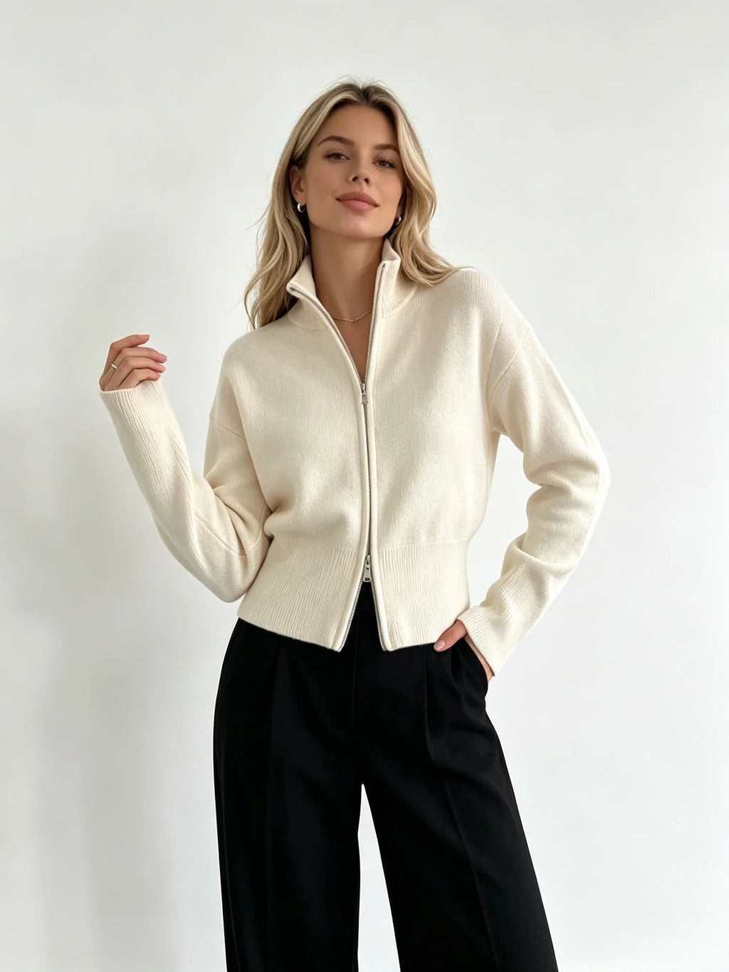 Ivory zip up cardigan with high stand collar worn with black wide-leg trousers