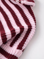Close-up of the thick striped knit on a burgundy cardigan