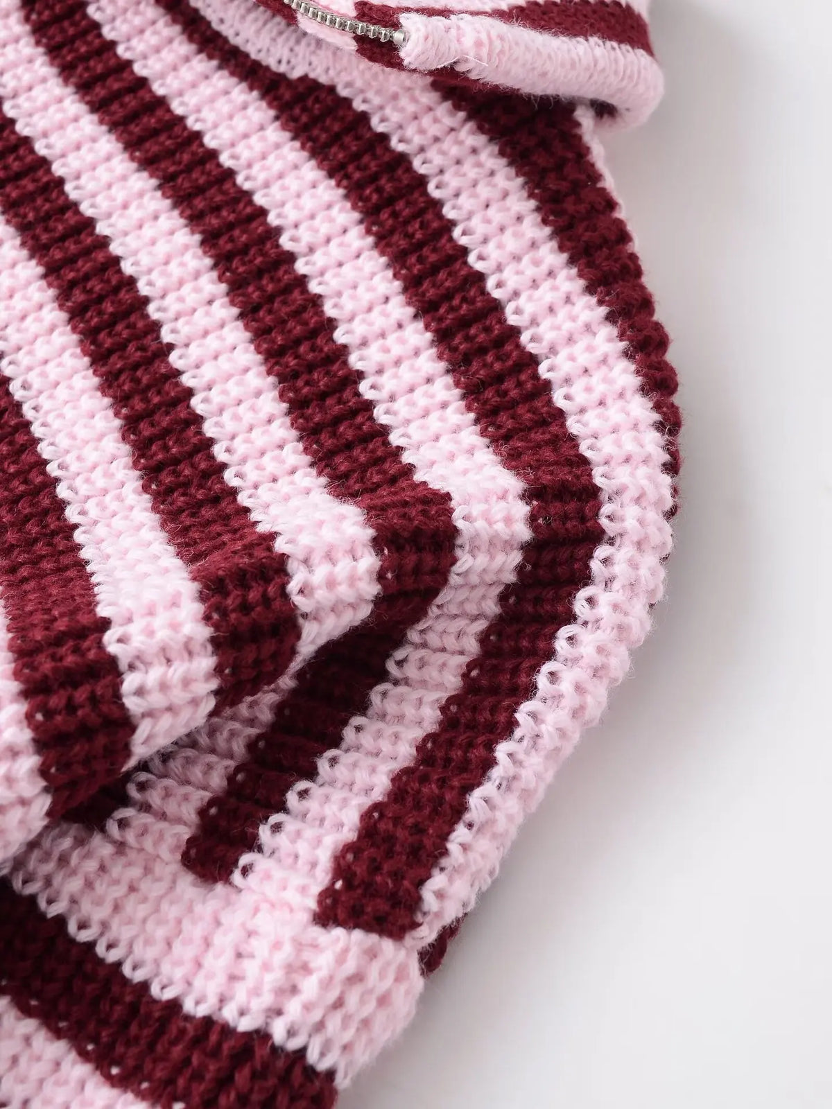 Close-up of the thick striped knit on a burgundy cardigan