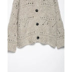 Open knit pattern and black buttons on an oatmeal cardigan