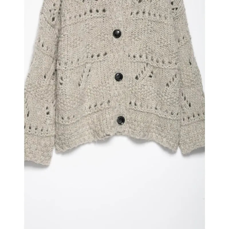 Open knit pattern and black buttons on an oatmeal cardigan