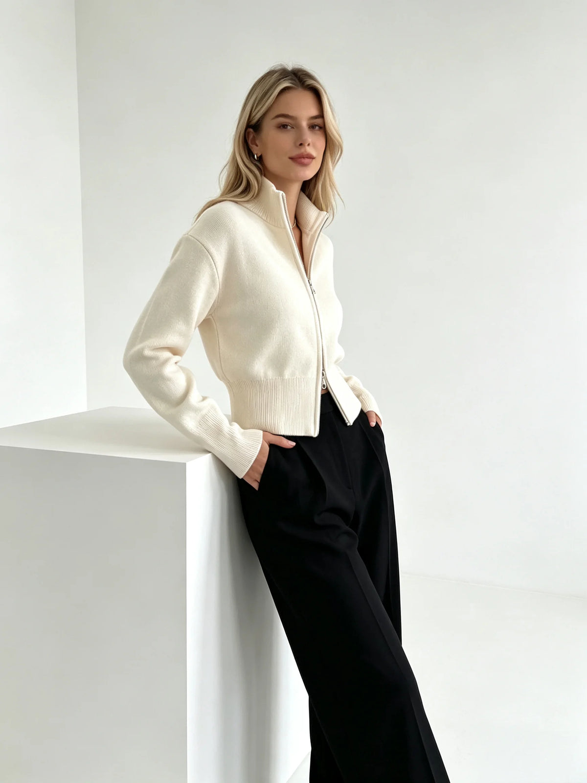 Ivory zip up cardigan with stand collar, leaning pose