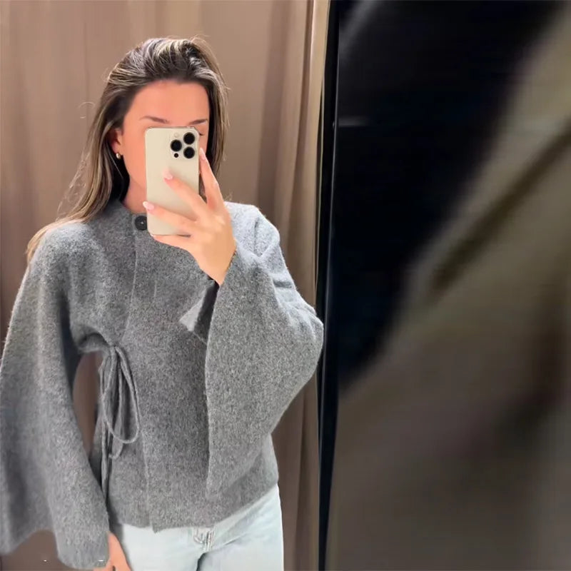 Grey knit cardigan with side tie and split sleeves, worn with jeans