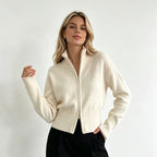 Ivory zip up cardigan with stand collar and black trousers