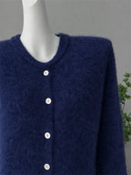 Close-up of the crew neck and buttons on a navy cardigan