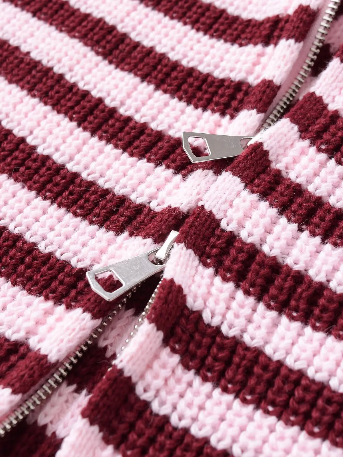 Close-up of the zip pulls on a burgundy striped cardigan